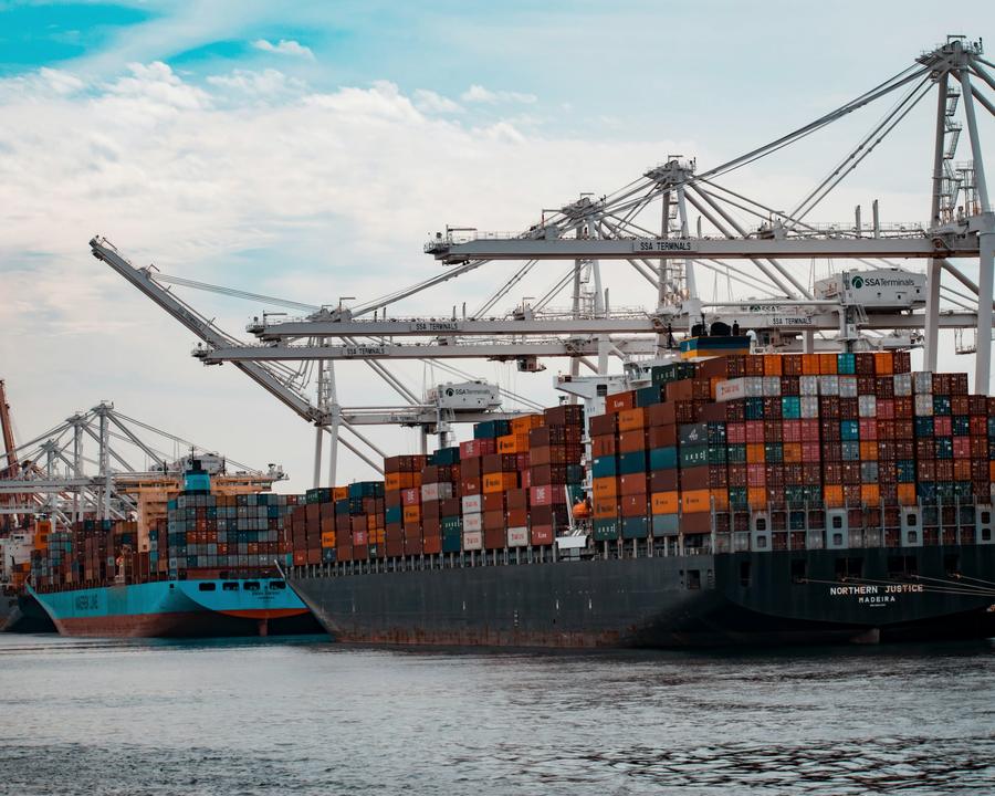 Container ships being worked under ship-to-shore cranes at a port