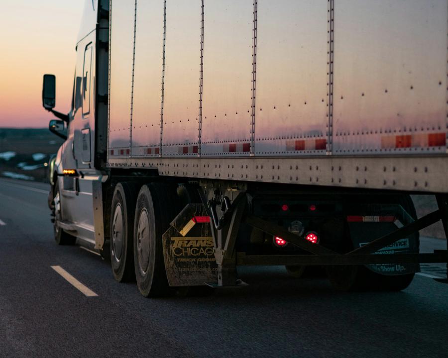 Freight truck and trailer on the road at sunset