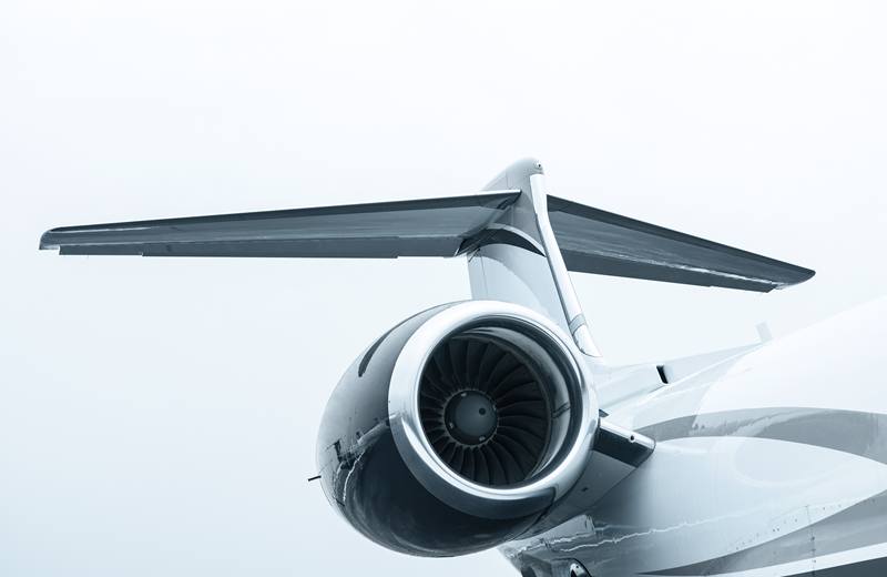 Close-up of an aircraft jet engine and tail against the sky